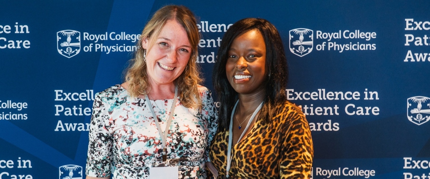 Two women receive an award at an event.