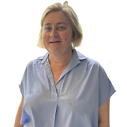A woman with short blond hair and in a blue shirt is smiling.