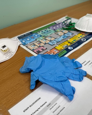 Glovesm masks and printed materials are placed on a table for one of the escape room activities.