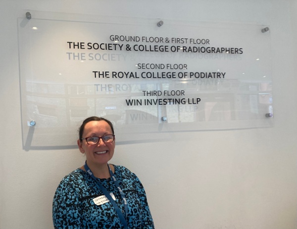 Cath Matthams standing next to the Society and College of Radiographers sign