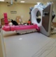 A white ring-shaped machine with a bed.