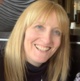 A woman with blind hair is smiling.