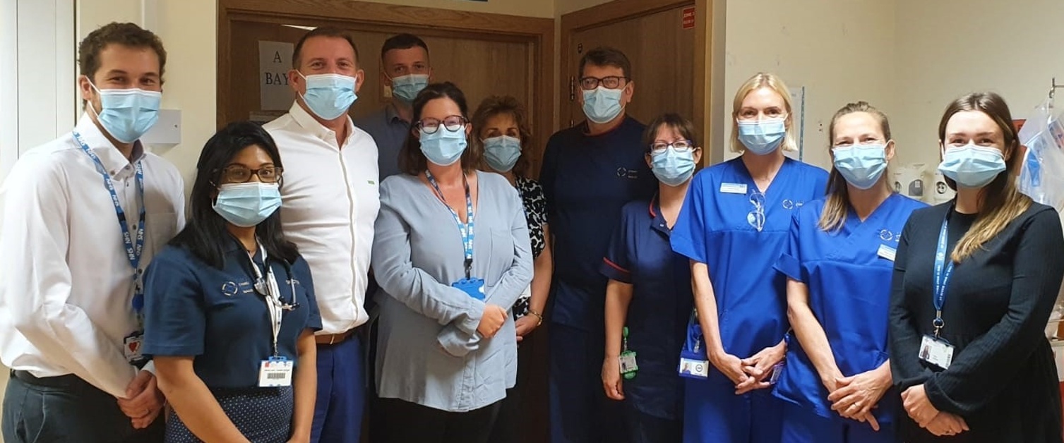A group of clinicians stand with masks on.