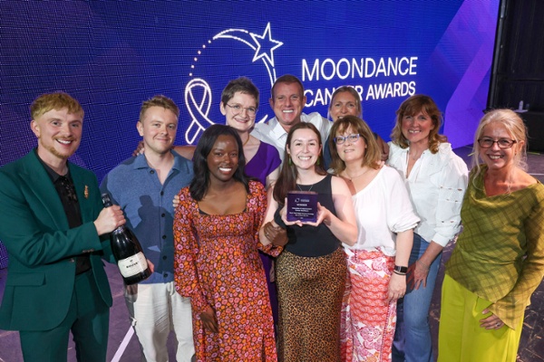 A group of people receive an award on stage.