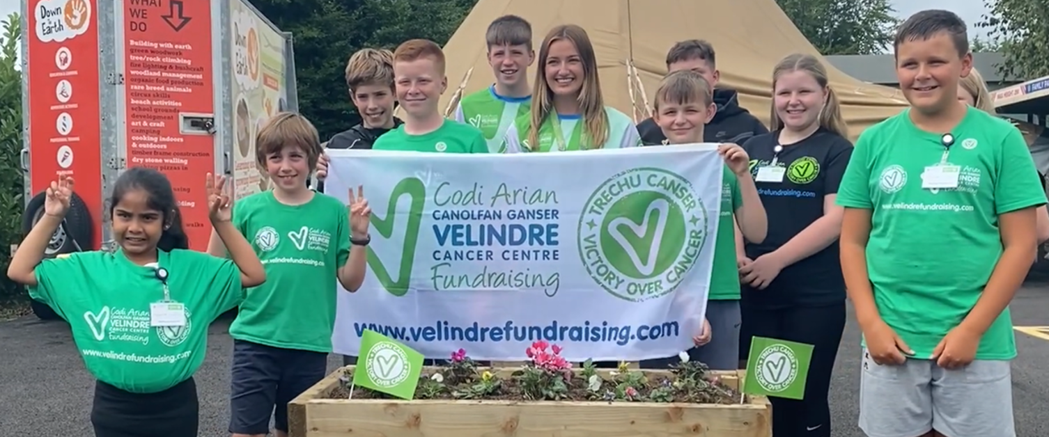 A group of people hold a flag for Velindre.