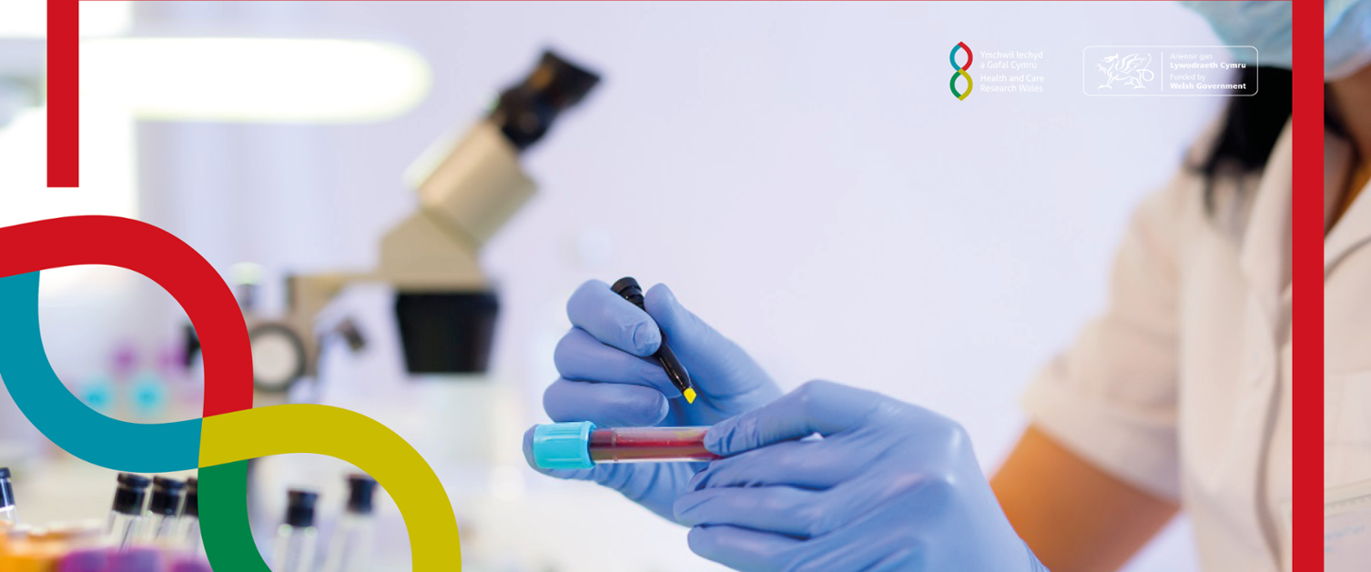 A person in a lab is wearing gloves and marking a blood sample with a pen.