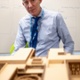 A man in a blue shirt is next to a model of the new Velindre Cancer Centre.