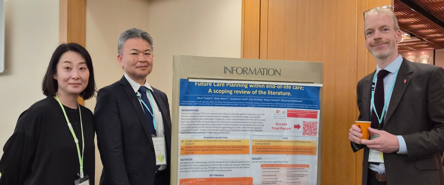 Mark is stood next to his conference poster. Two colleagues are also there.