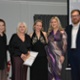 Pobl yn derbyn eu gwobr ac yn gwenu.