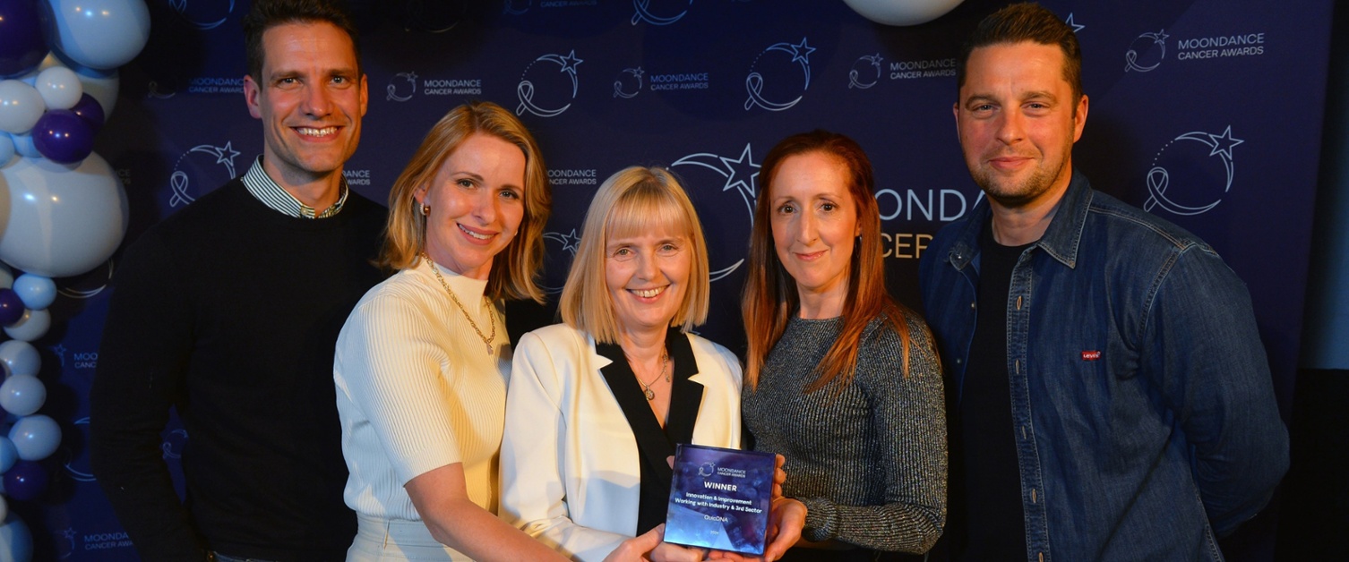 A group of people are holding an award and smiling.