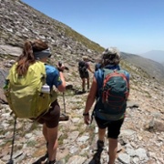 A group of people are trekking across a mountian.