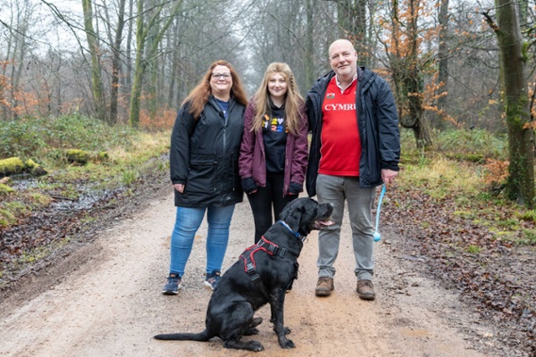 Isabel and her family walk their dog in the woods.